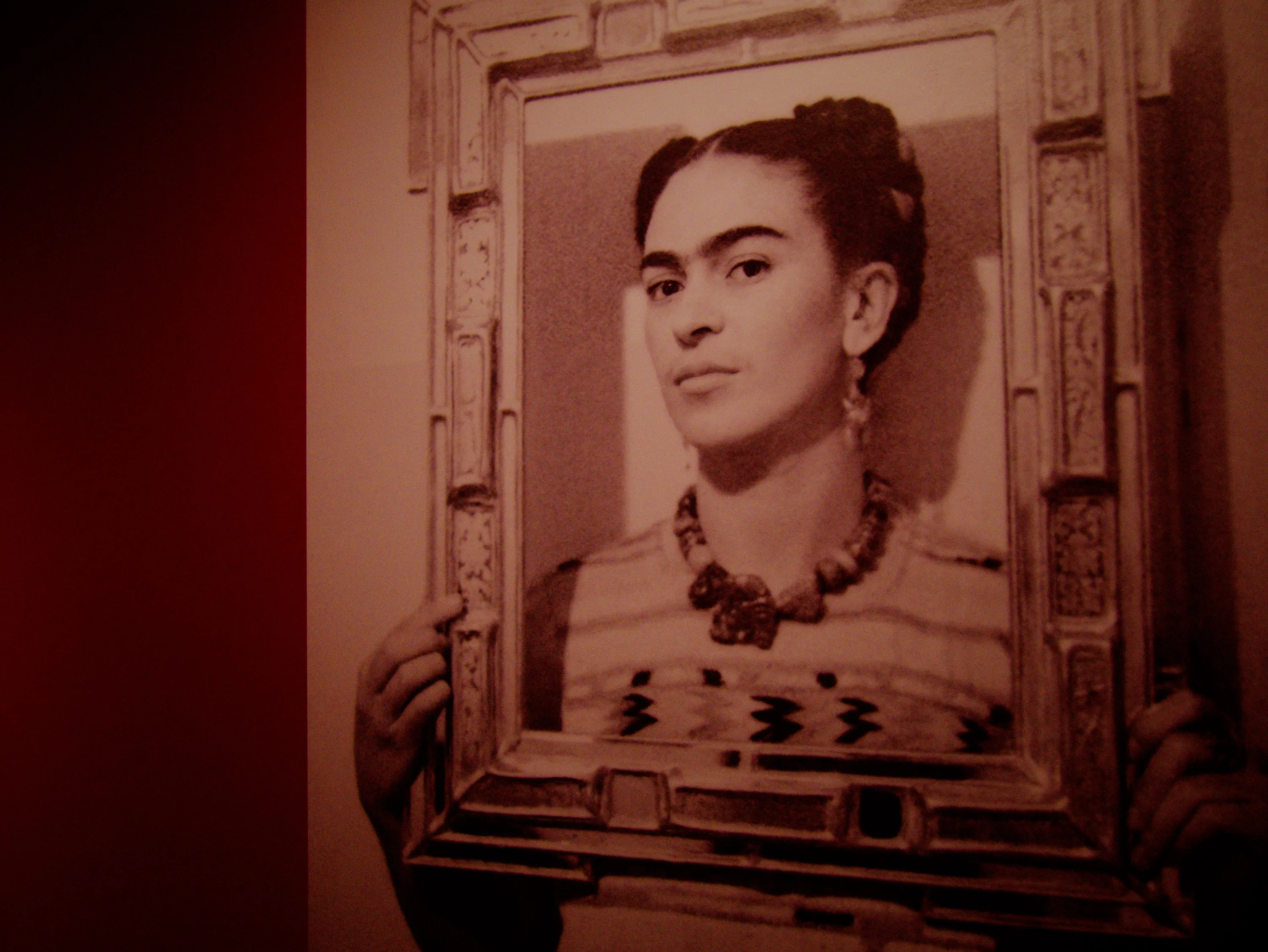Frida Kahlo holding an empty frame around her face